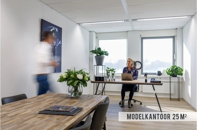 Modern modelkantoor van 25 m² aan de Baarnsche Dijk met een werkruimte, vergadertafel en veel natuurlijk licht.